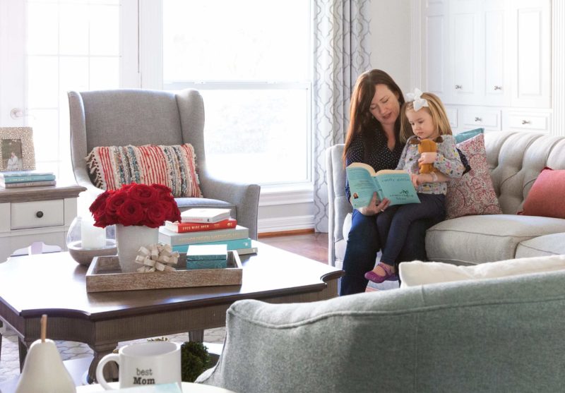mother and child sitting on couch reading